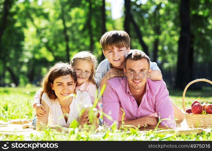 Happy family having weekend in summer park. Picnic in garden