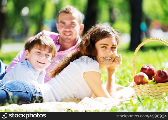 Happy family having weekend in summer park. Picnic in garden