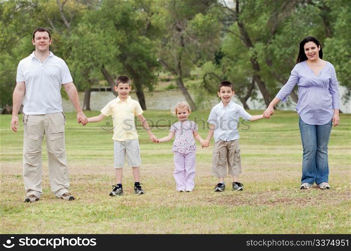 Happy family holding hands on a natural background