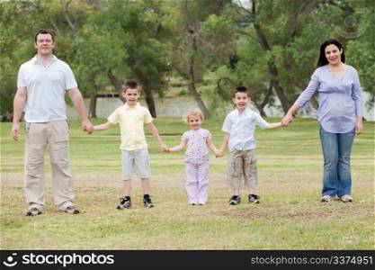 Happy family holding hands on a natural background
