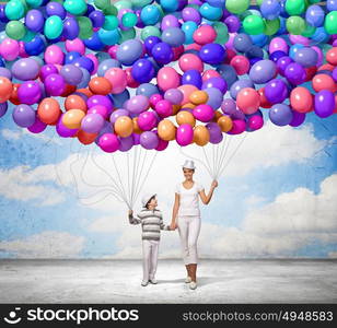 Happy family. Image of mother and son holding bunch of colorful balloons