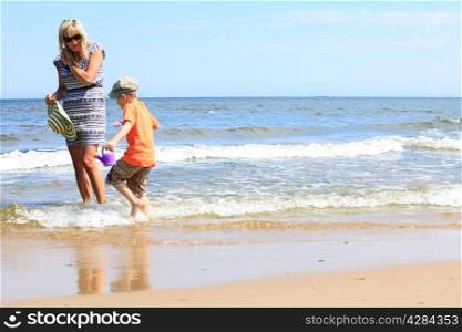 happy family in action mother and son playing on beach