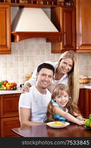 Happy family in kitchen look in camera