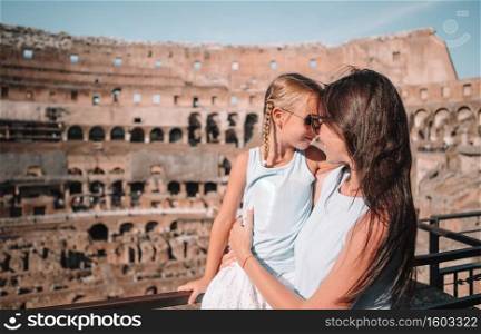 Happy family in Rome background of Coliseum. Family portrait at famous places in Europe. Young mother and little girl hugging in Coliseum, Rome, Italy.