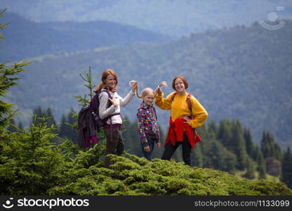 happy family in the mountains. mother with daughters are walking in the mountains