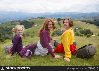 happy family in the mountains. mother with daughters relax in the mountains