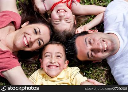 Happy family laying in the circle on green grass in the park,outdoor
