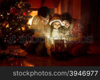 Happy family looking inside of magic Christmas gift box