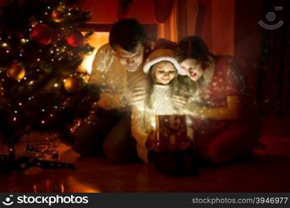 Happy family looking inside of magic Christmas gift box