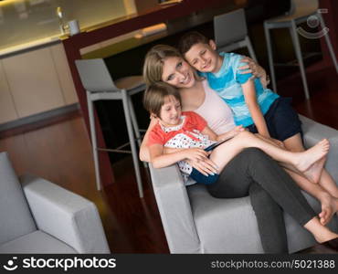 Happy Family Lying Down On The Sofa And Using Tablet