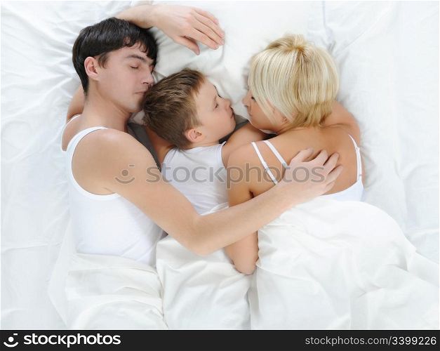 Happy family lying in bed in the morning