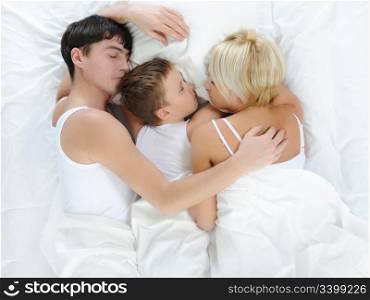 Happy family lying in bed in the morning