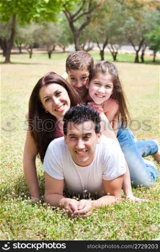 Happy family lying in the grass field in park,outdoor