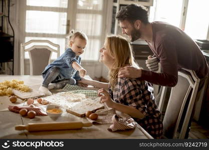 Happy family making pasta in the kitchen at home