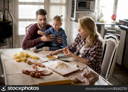 Happy family making pasta in the kitchen at home