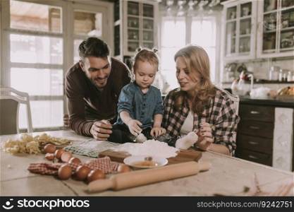 Happy family making pasta in the kitchen at home