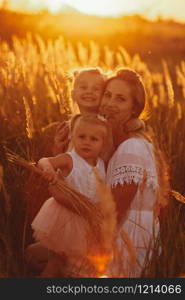 happy family, mom and two daughters. Mother and daughter on sunset in the forest. family concept. Mother plays with her daughter on the street in the park at sunset.. happy family, mom and two daughters. Mother plays with her daughter on the street in at sunset. family concept