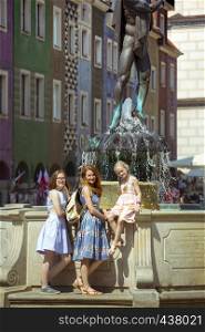 Happy family - mom and two daughters on a square Rynek of polish city Poznan