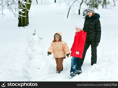 Happy family (mother with small boy and girl) in winter city park