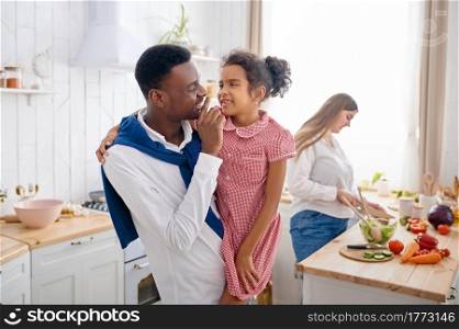 Happy family, nice breakfast on the kitchen. Mother, father and their daughter cooking in the morning, good relationship. Happy family, nice breakfast on the kitchen