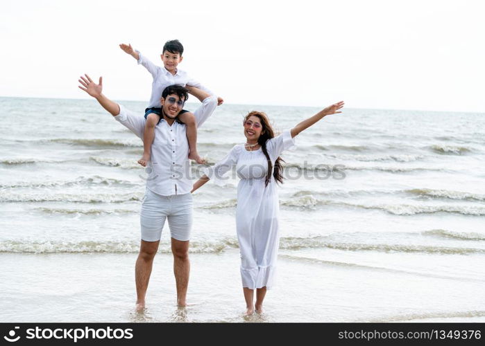 Happy family of father, mother and kids goes vacation on a tropical sand beach in summer.. Happy family goes vacation on the beach in summer.