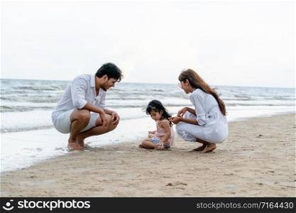 Happy family of father, mother and kids goes vacation on a tropical sand beach in summer.. Happy family goes vacation on the beach in summer.