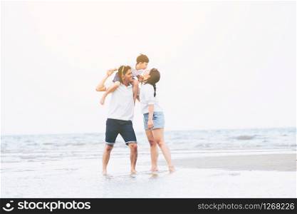 Happy family of father, mother and son goes vacation on a tropical sand beach in summer.