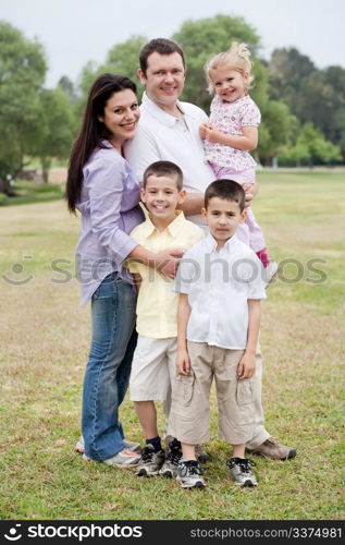 Happy family of five posing on natural background