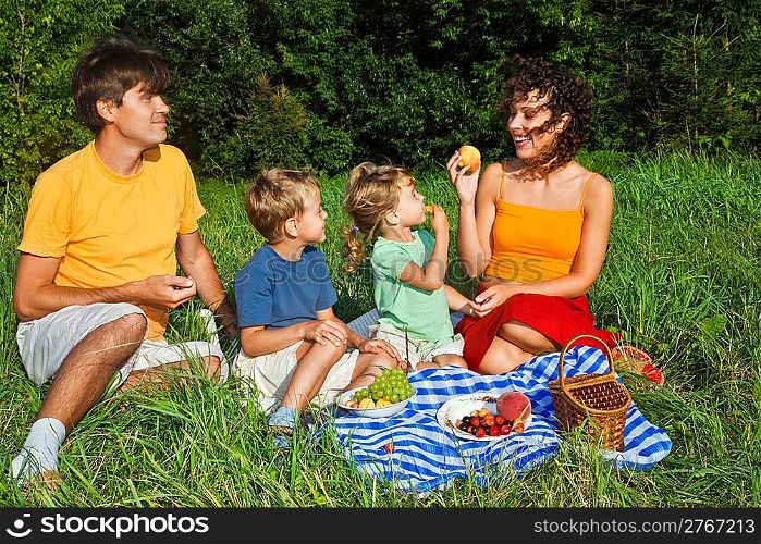 happy family of four on picnic in garden