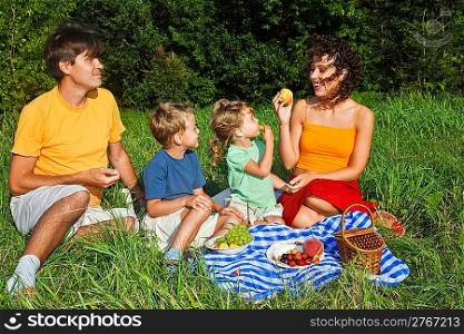 happy family of four on picnic in garden