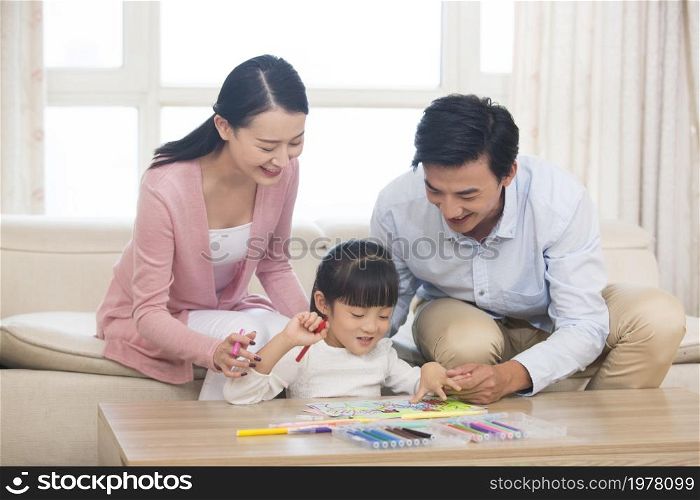Happy family of three drawing pictures