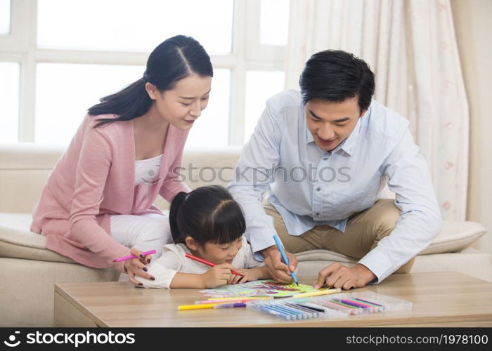 Happy family of three drawing pictures