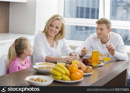 Happy family of three having breakfast at table