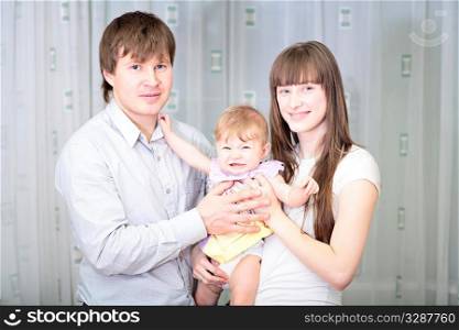 Happy family of three person together and smiling indoors