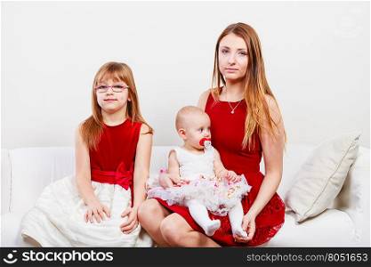 Happy family of three women. Beauty of motherhood. Happy positive family sitting together. Mommy with two little girls daughters. Three lovely women.