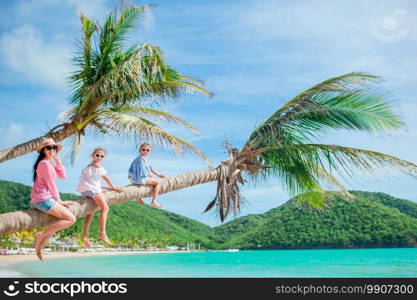 Happy family on a beach during summer vacation. Young family on vacation have a lot of fun on palmtree