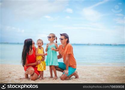 Happy family on a beach during summer vacation. Young family on summer beach vacation
