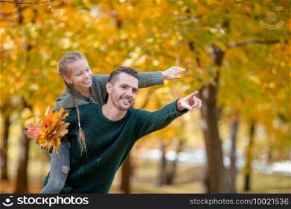Happy family on beautiful autumn day outdoors. Father and his little daughter together in autumn park. Family of dad and kid on beautiful autumn day in the park