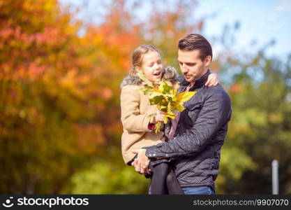 Happy family on beautiful autumn day outdoors. Father and his little daughter together in autumn park. Family of dad and kid on beautiful autumn day in the park