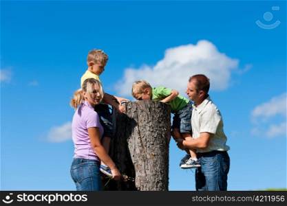 Happy family on excursion in summer - they discovered a trunk