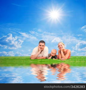 Happy family on grass, sunny sky. Mother, father and a child.