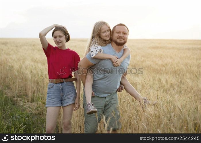 happy family outdoor. dad with daughters at the field