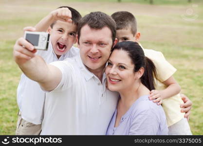 Happy family pilled together and taking self portrait on natural background