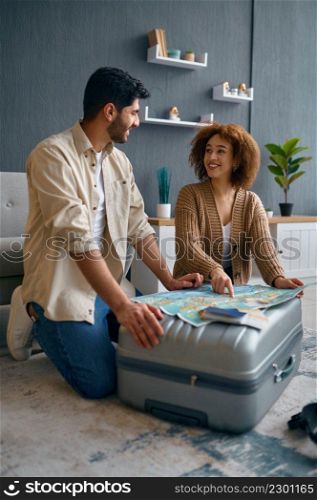 Happy family planning travel vacation. Young interracial couple discussing touristic rout on map. Happy young family couple planning travel vacation