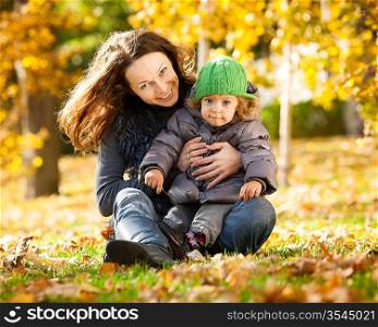 Happy family playing against blurred yellow leaves background in autumn park