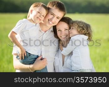 Happy family playing outdoors in spring green field