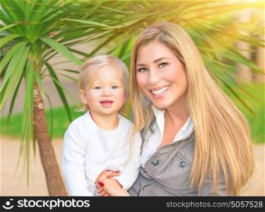 Happy family portrait, cute smiling mother holding on hands her little adorable daughter, enjoying motherhood, love and happiness concept
