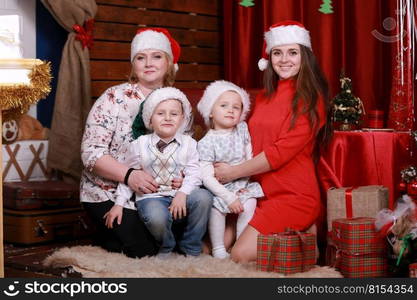 Happy family posing for photo at christmas. grandmother and mother with two children in santa hats.. Happy family posing for photo at christmas. grandmother and mother with two children in santa hats