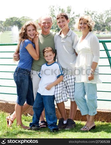 Happy family posing infront of the lake on a sunny day