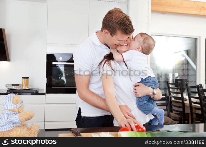 Happy family preparing a meal and getting a big hug